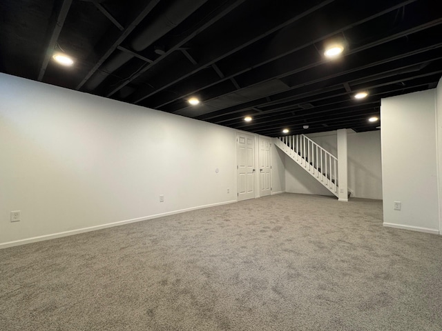 finished basement with stairway, carpet, and baseboards