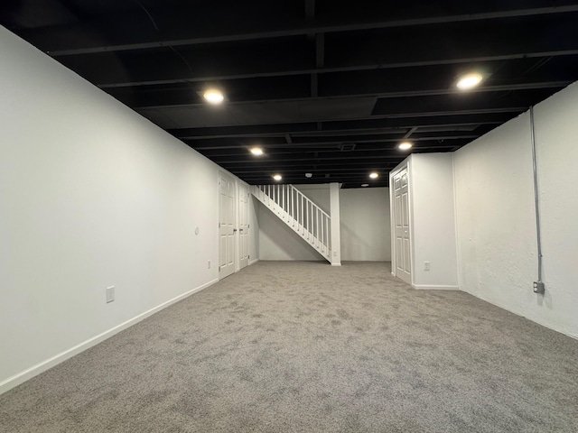 finished basement featuring stairs, baseboards, and carpet flooring