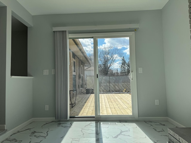 doorway featuring marble finish floor and baseboards