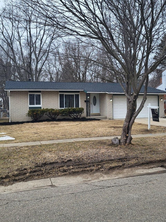 view of front of house featuring an attached garage, a front lawn, and brick siding