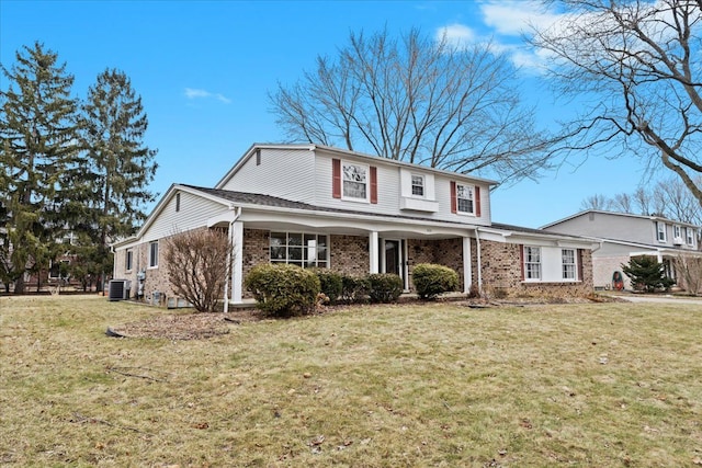 traditional home featuring a front yard, central AC unit, and brick siding