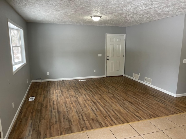 unfurnished room with wood finished floors and visible vents