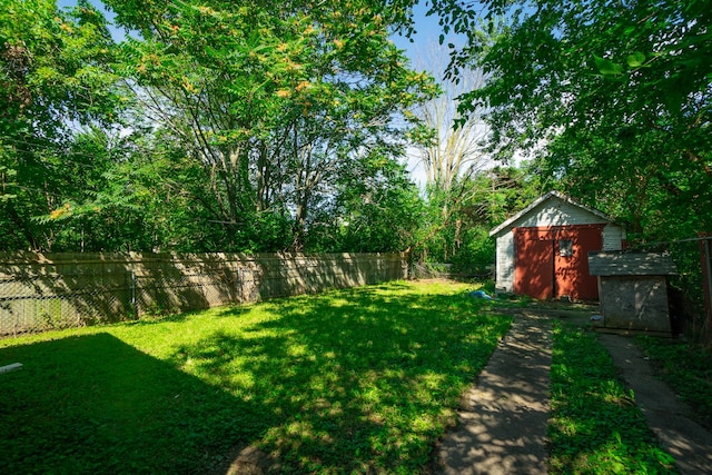 view of yard with an outbuilding, a fenced backyard, and a storage shed