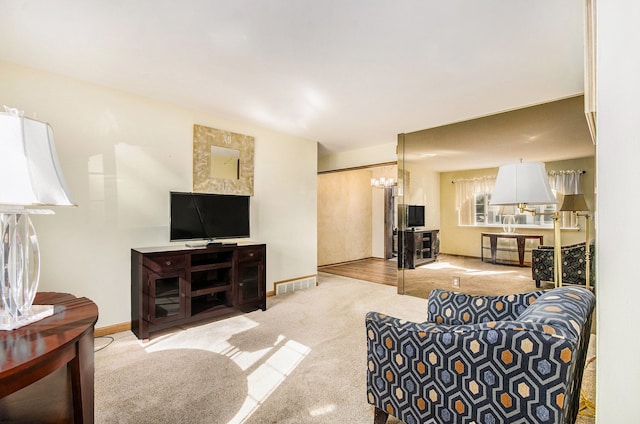 carpeted living area featuring visible vents and baseboards