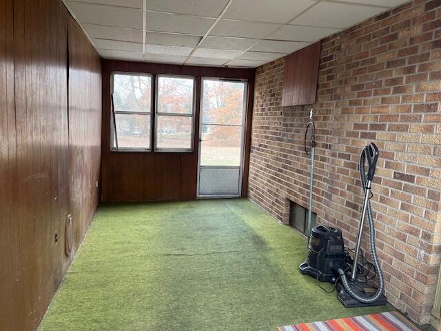 unfurnished sunroom featuring a drop ceiling