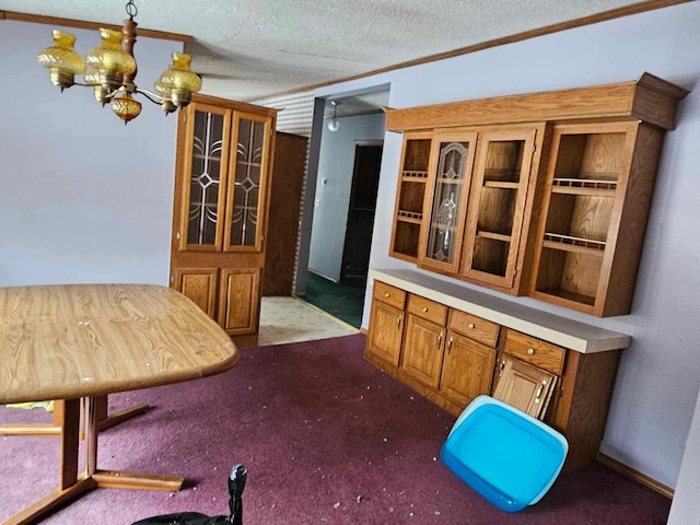 dining area with a textured ceiling, carpet flooring, and a notable chandelier