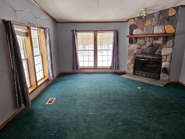 unfurnished living room with a textured ceiling, carpet floors, a fireplace, visible vents, and crown molding