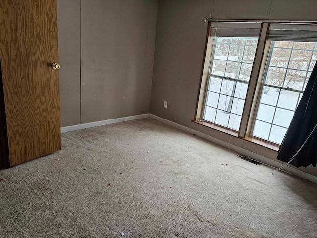 empty room featuring carpet flooring and baseboards