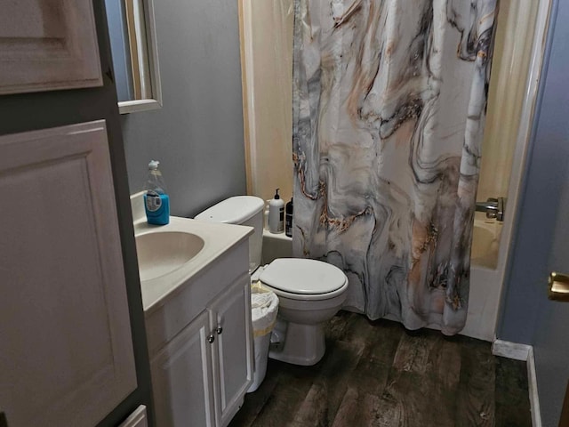 full bath with toilet, wood finished floors, vanity, and shower / bathtub combination with curtain