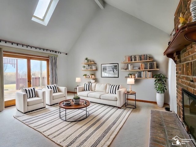 living room with high vaulted ceiling, a fireplace, a skylight, baseboards, and carpet