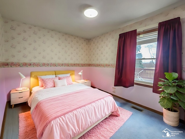 bedroom with visible vents, baseboards, and wallpapered walls