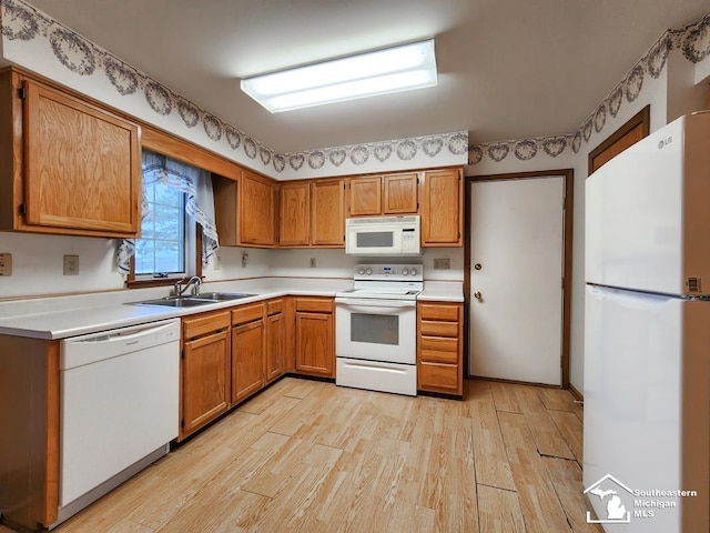 kitchen with white appliances, light wood-style floors, a sink, and light countertops