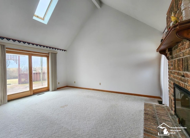 unfurnished living room with high vaulted ceiling, a skylight, baseboards, a brick fireplace, and carpet