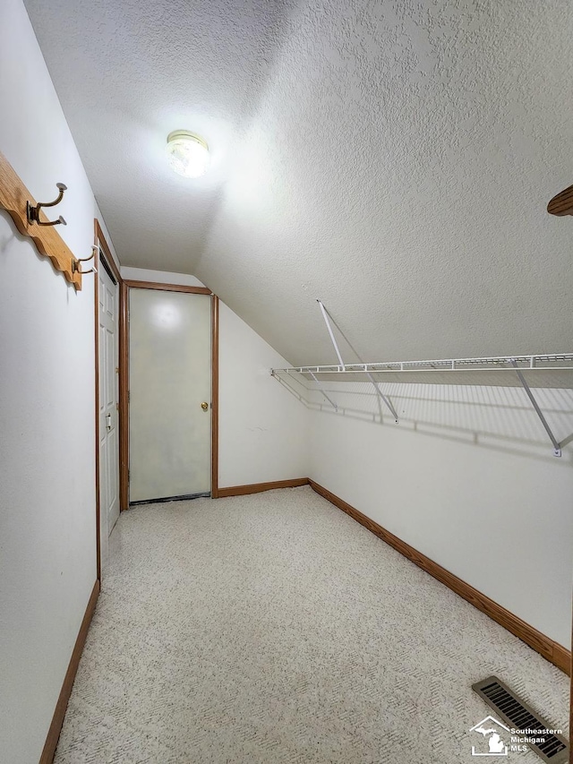 spacious closet featuring lofted ceiling and visible vents