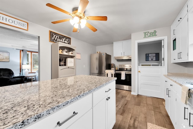 kitchen with appliances with stainless steel finishes, white cabinetry, under cabinet range hood, and light wood finished floors