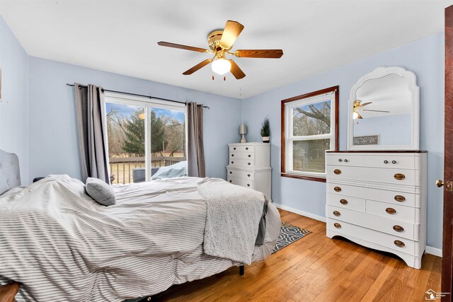 bedroom featuring baseboards, ceiling fan, light wood-type flooring, and access to exterior