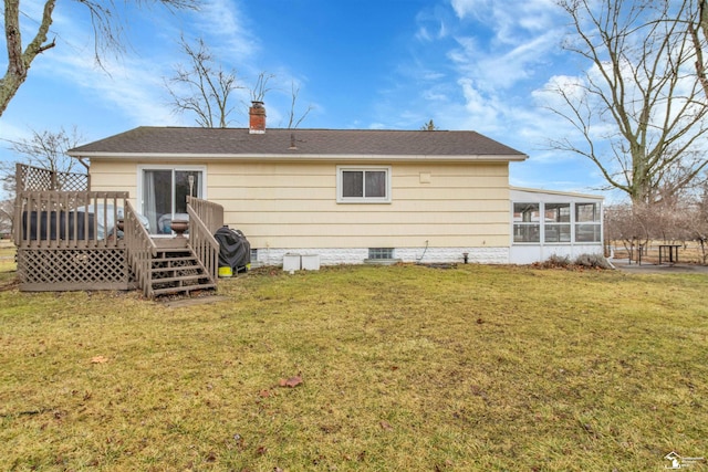 back of property featuring a sunroom, a lawn, a chimney, and a wooden deck