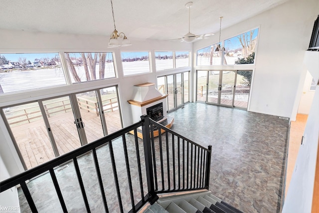 stairs featuring a textured ceiling, a high ceiling, and a wealth of natural light