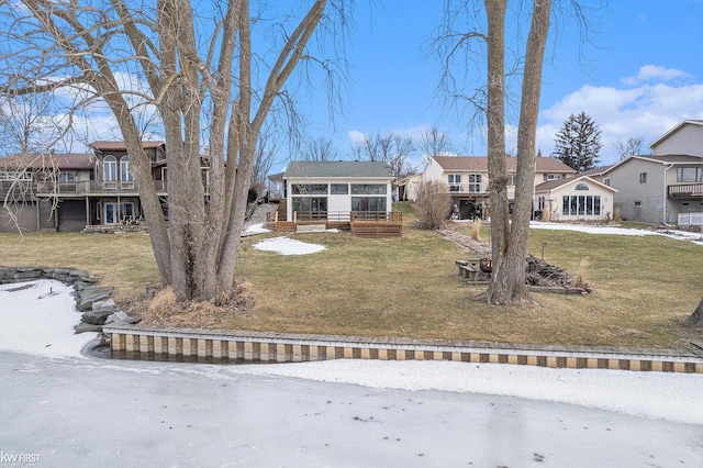 view of front of property with a sunroom, a residential view, and a front lawn