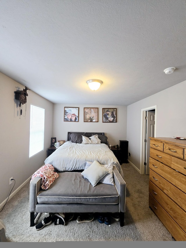 bedroom with dark carpet, a textured ceiling, and baseboards