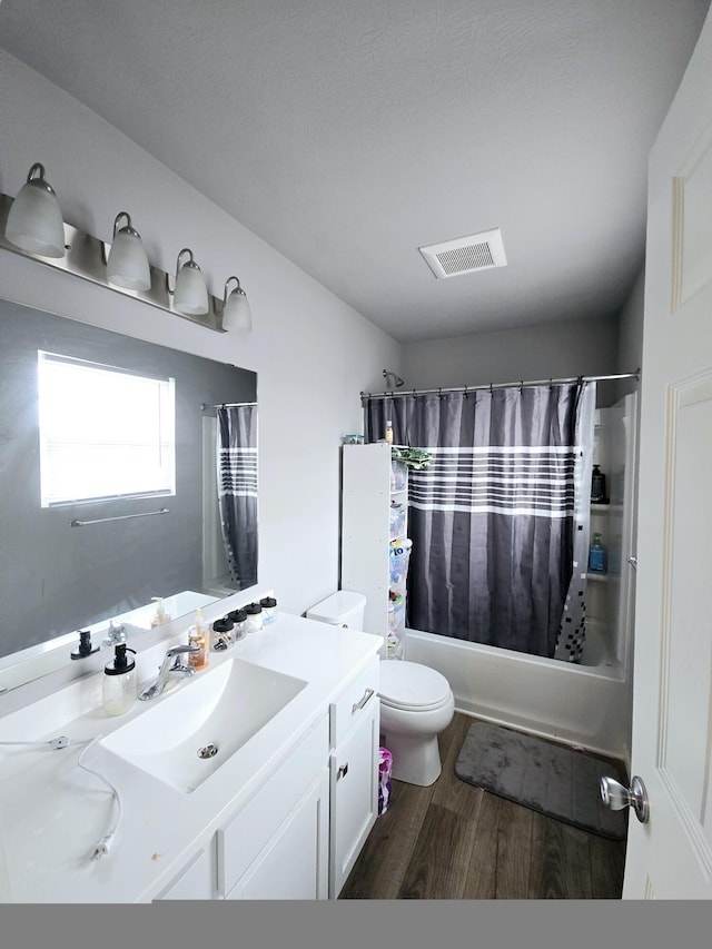 bathroom with toilet, wood finished floors, vanity, visible vents, and shower / bathtub combination with curtain