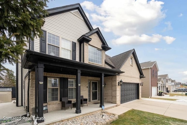 view of front of property with covered porch, driveway, and brick siding