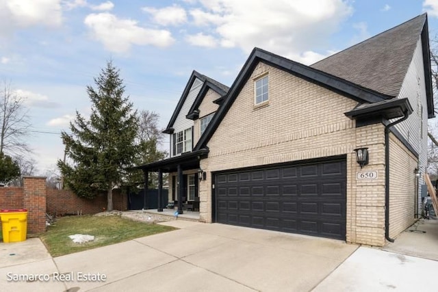 view of property exterior with a garage, brick siding, fence, driveway, and a lawn