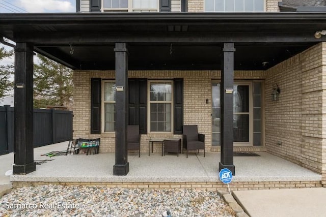 view of patio with a porch and fence