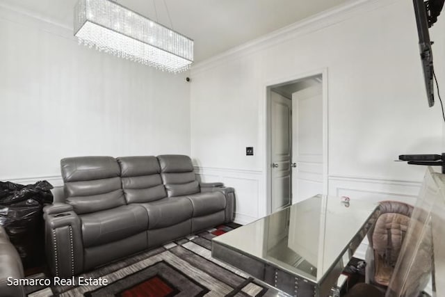 living area with ornamental molding, a wainscoted wall, and a decorative wall