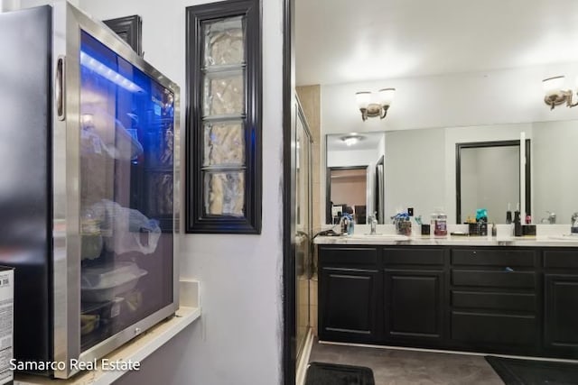 full bathroom with an enclosed shower, a sink, and double vanity