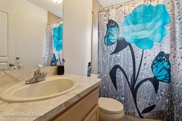 bathroom featuring a shower with shower curtain, vanity, and toilet