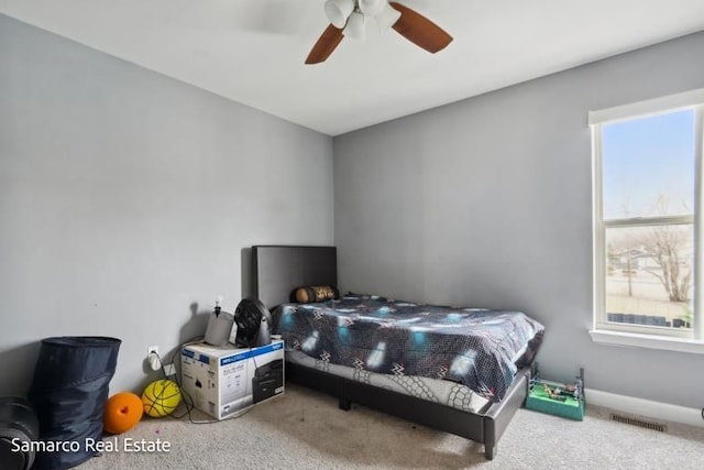 bedroom with baseboards, carpet, visible vents, and a ceiling fan