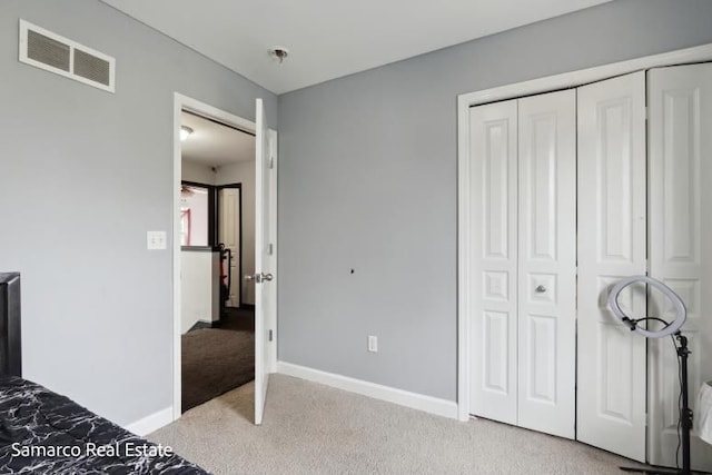 unfurnished bedroom with baseboards, a closet, visible vents, and light colored carpet