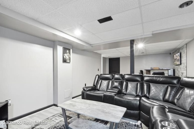 cinema with baseboards, a drop ceiling, visible vents, and light wood-style floors