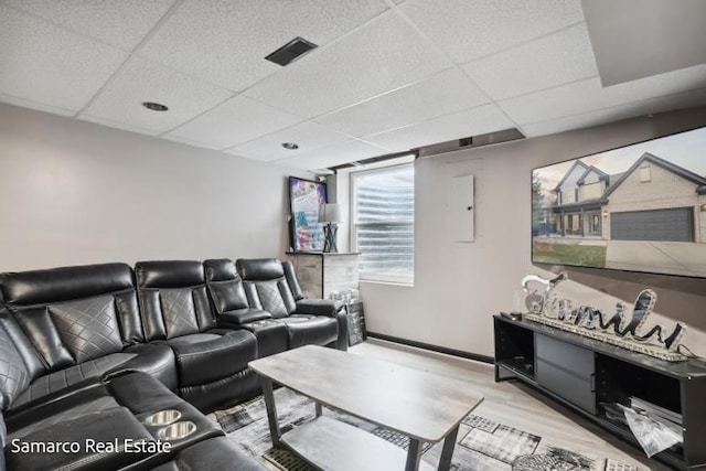 living area with a paneled ceiling, visible vents, and wood finished floors