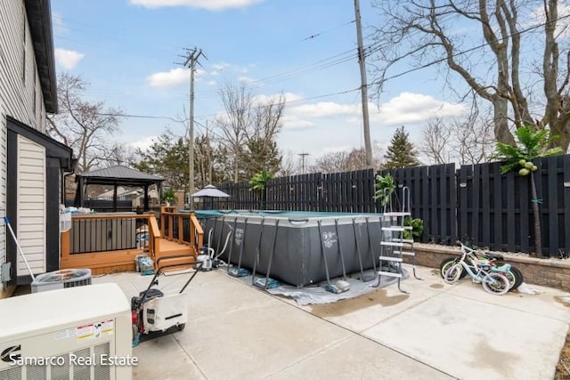 view of patio with a fenced in pool, fence, and a gazebo