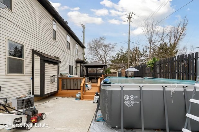 exterior space with a patio, central AC, fence, a gazebo, and a fenced in pool