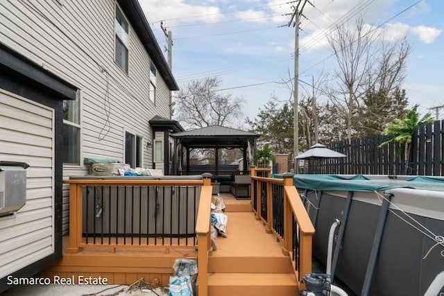 wooden terrace featuring fence and a gazebo