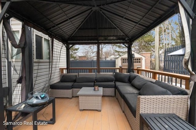 wooden deck with a shed, an outdoor structure, a fenced backyard, and an outdoor living space