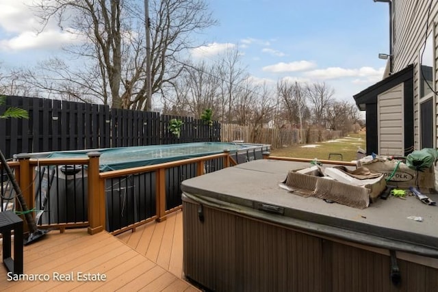 wooden deck featuring fence, a pool, and a hot tub