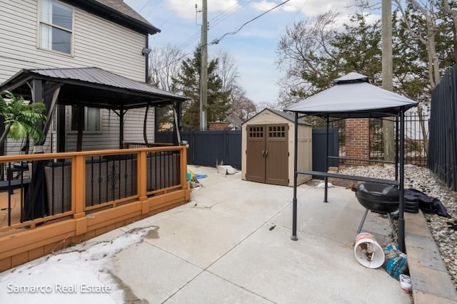 view of patio / terrace with a fenced backyard, an outdoor structure, a gazebo, and a shed