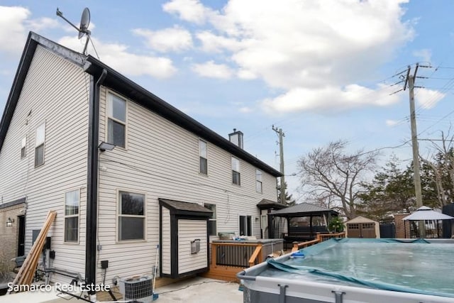 back of house with a deck, a gazebo, and central AC