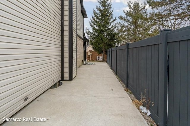 view of side of property featuring a patio and fence