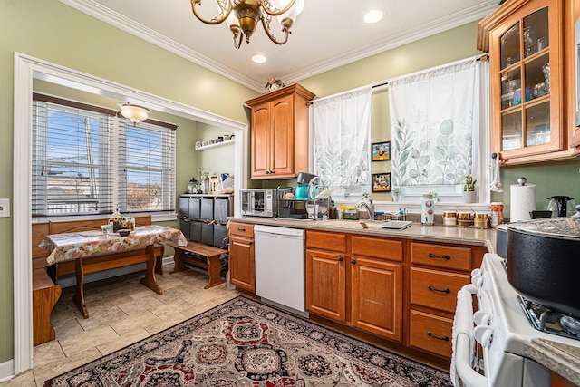 kitchen featuring white appliances, glass insert cabinets, a notable chandelier, crown molding, and a sink