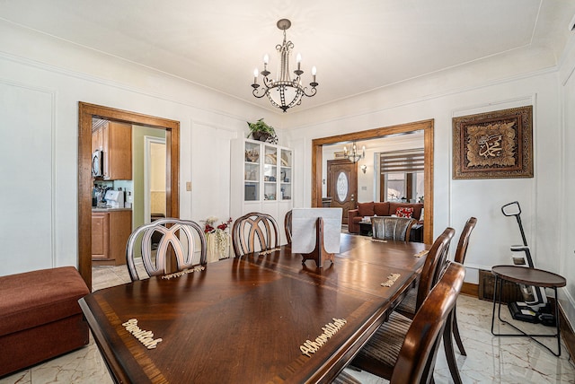 dining space with marble finish floor, a notable chandelier, and baseboards