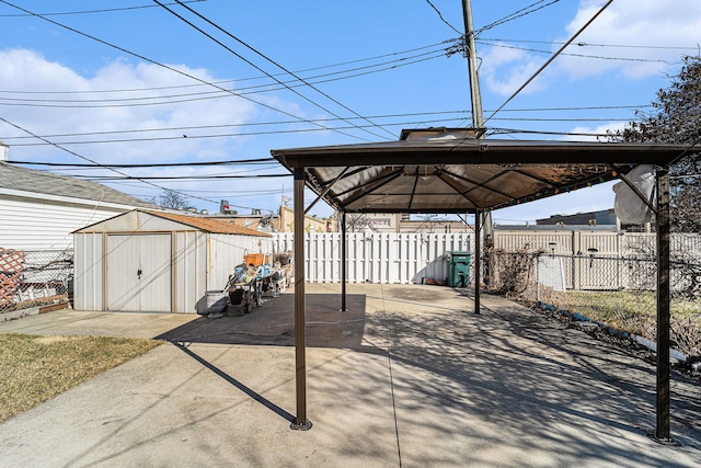 view of patio / terrace featuring fence, a storage unit, a gazebo, an outdoor structure, and a carport