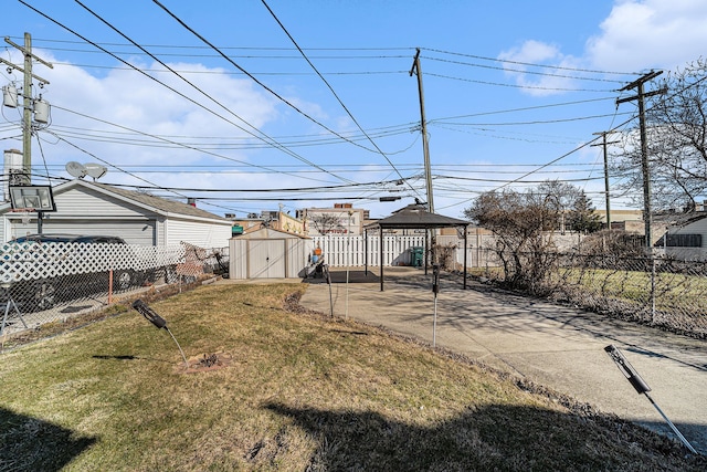 view of yard featuring a gazebo, fence private yard, an outbuilding, and a storage unit