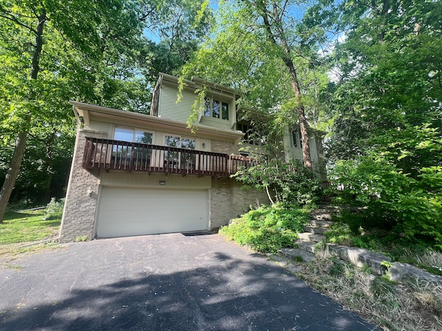 view of front of property featuring aphalt driveway, brick siding, and an attached garage