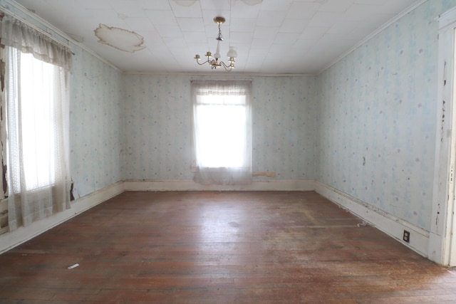 unfurnished room with a chandelier, crown molding, hardwood / wood-style flooring, and wallpapered walls