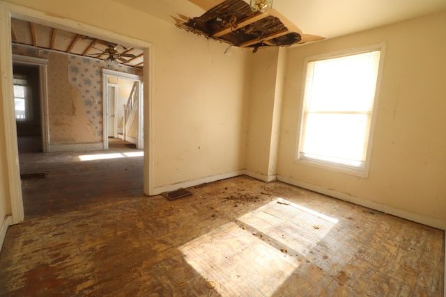 unfurnished room with baseboards and a ceiling fan